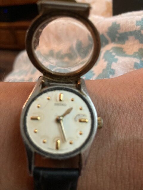 Foto van Debby’s braillehorloge, waarbij het glazen klepje over de wijzerplaat openstaat.